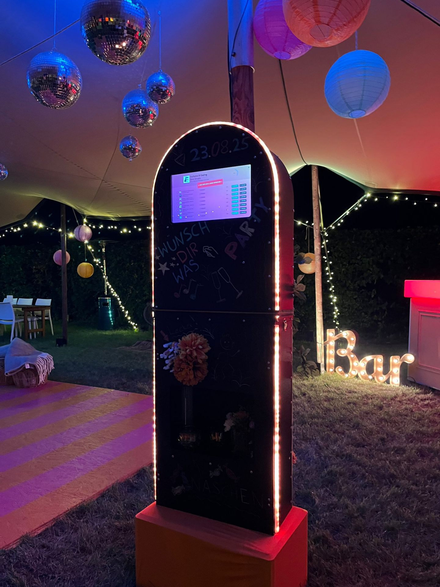 Jukebox bei Outdoor-Party mit Discokugeln und Lichtern